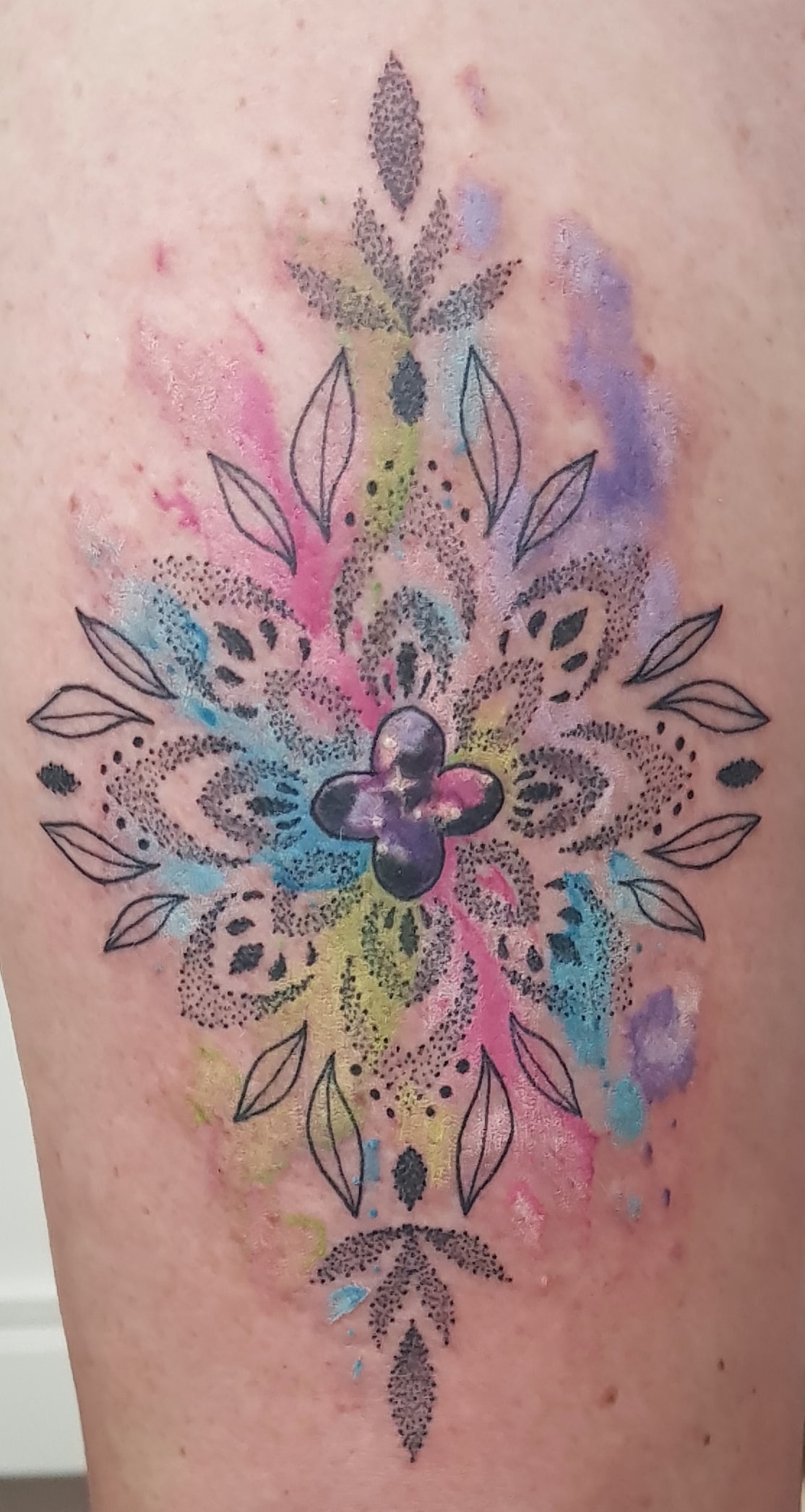 Ornamental watercolor style tattoo on the right